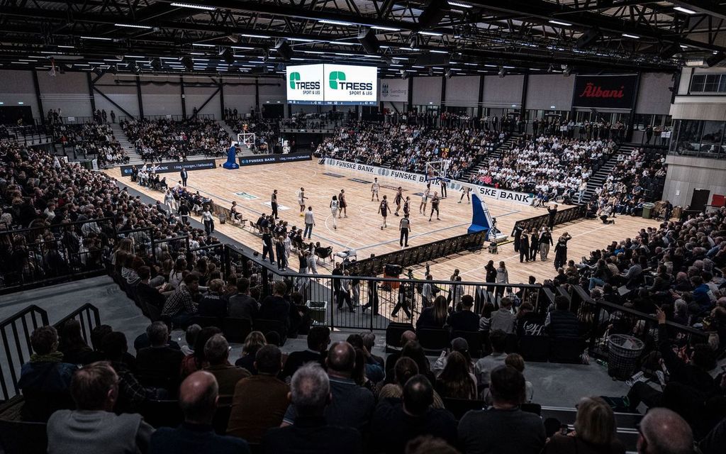 Illustration basketballspillere der spiller basket i en fyldt hal