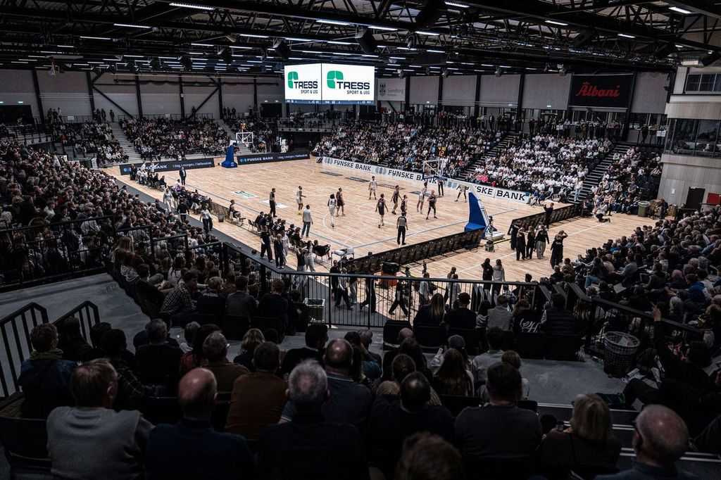 Illustration basketballspillere der spiller basket i en fyldt hal